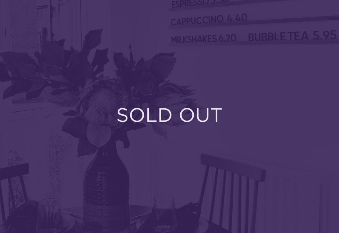 an image of flowers on a dining table, with a purple overlay and text that says sold out