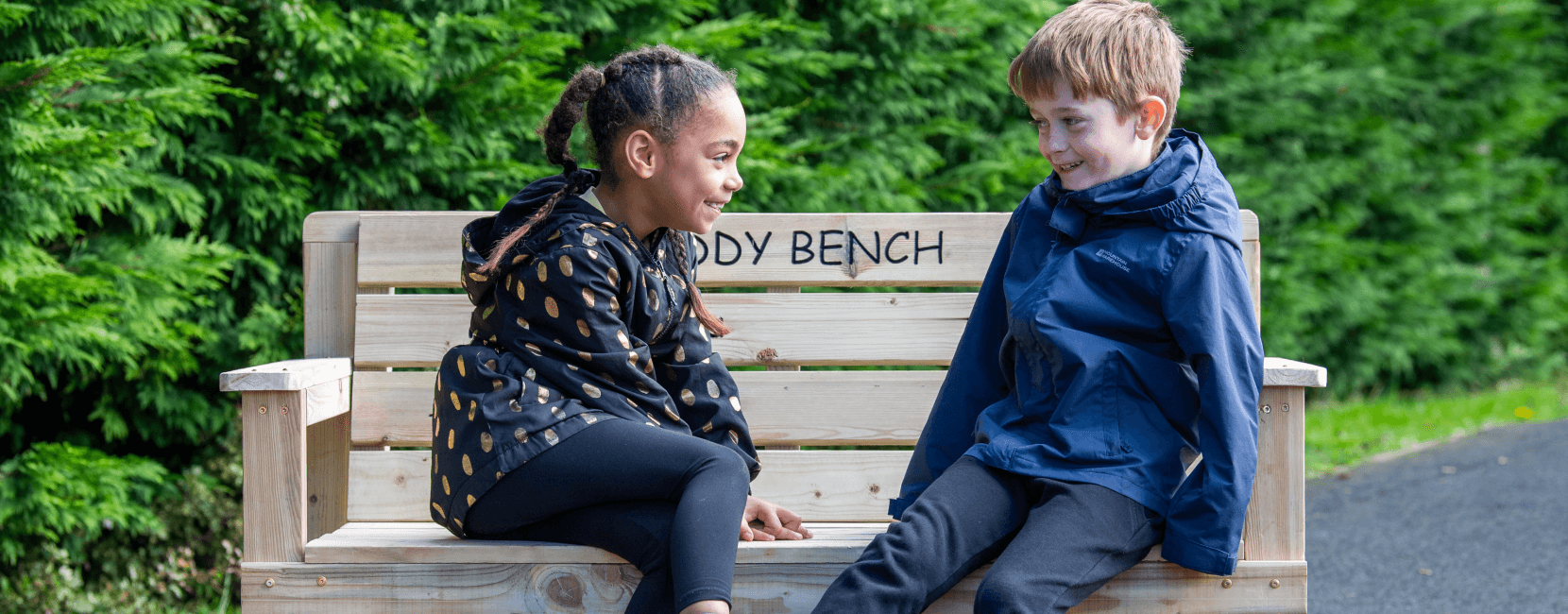 Two Young Children Sitting on Gifted Buddy Bench for World Mental Health Day