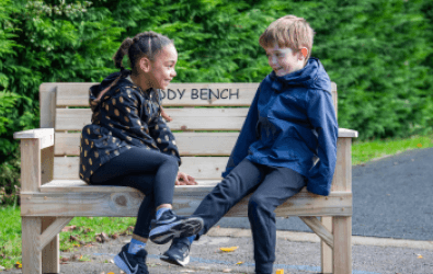 Two Young Children Sitting on Gifted Buddy Bench for World Mental Health Day